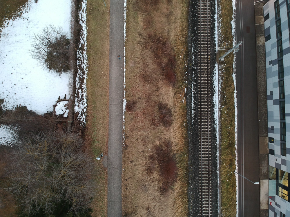 Drohnenfoto – Winterlandschaft als top down Foto mit Wanderweg.