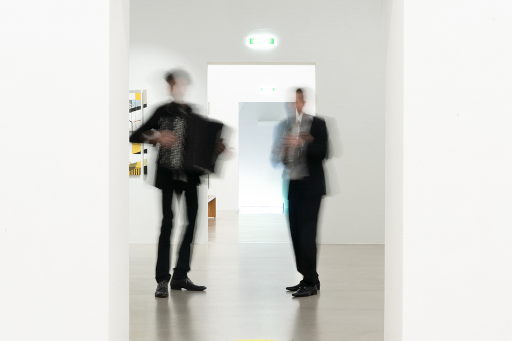 Business Porträt Duo-Klak – künstlerische Bewegungsaufnahme im Museumsflur, beide Musiker verwischt in Bewegung.